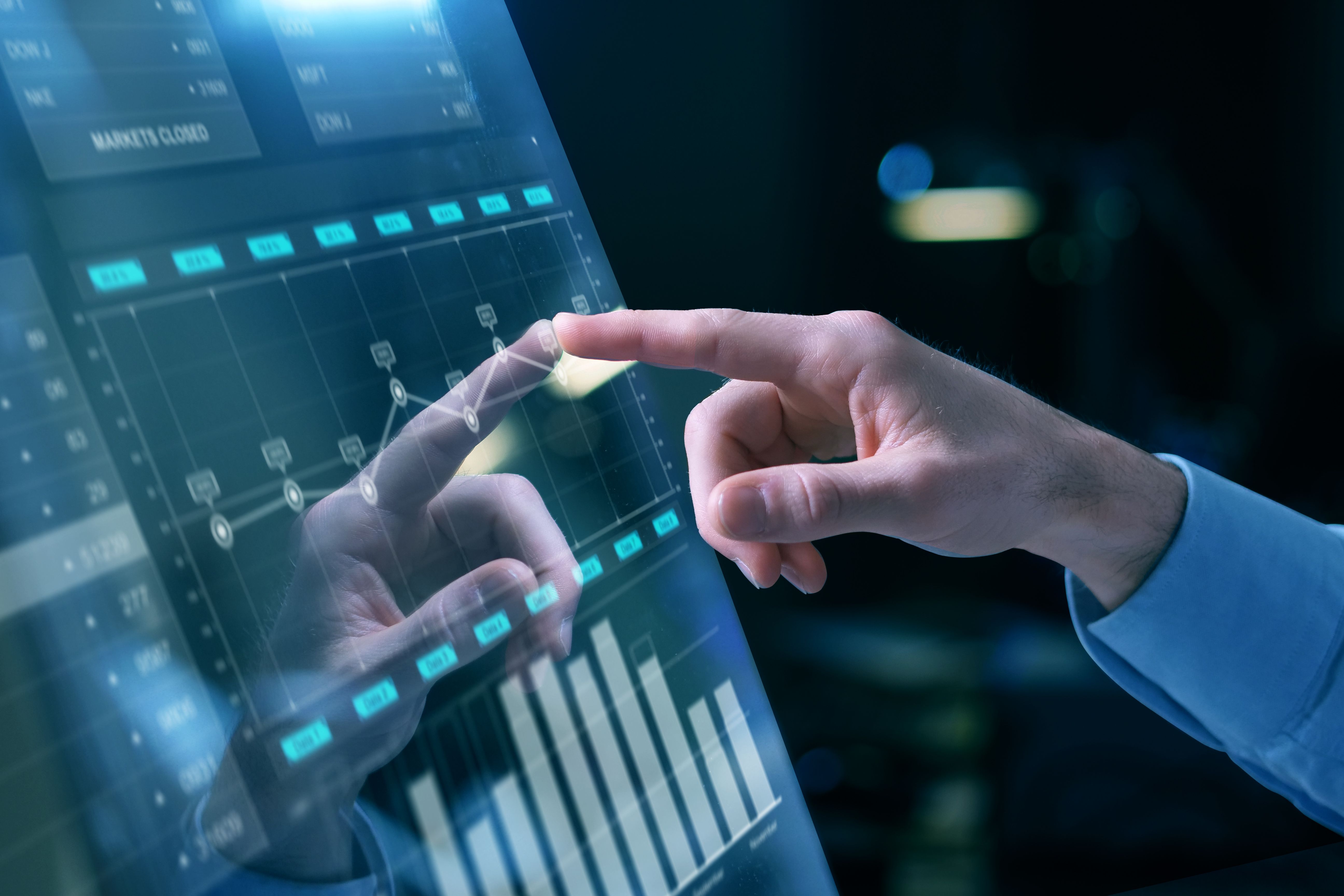 Hand touching a screen with data points on it