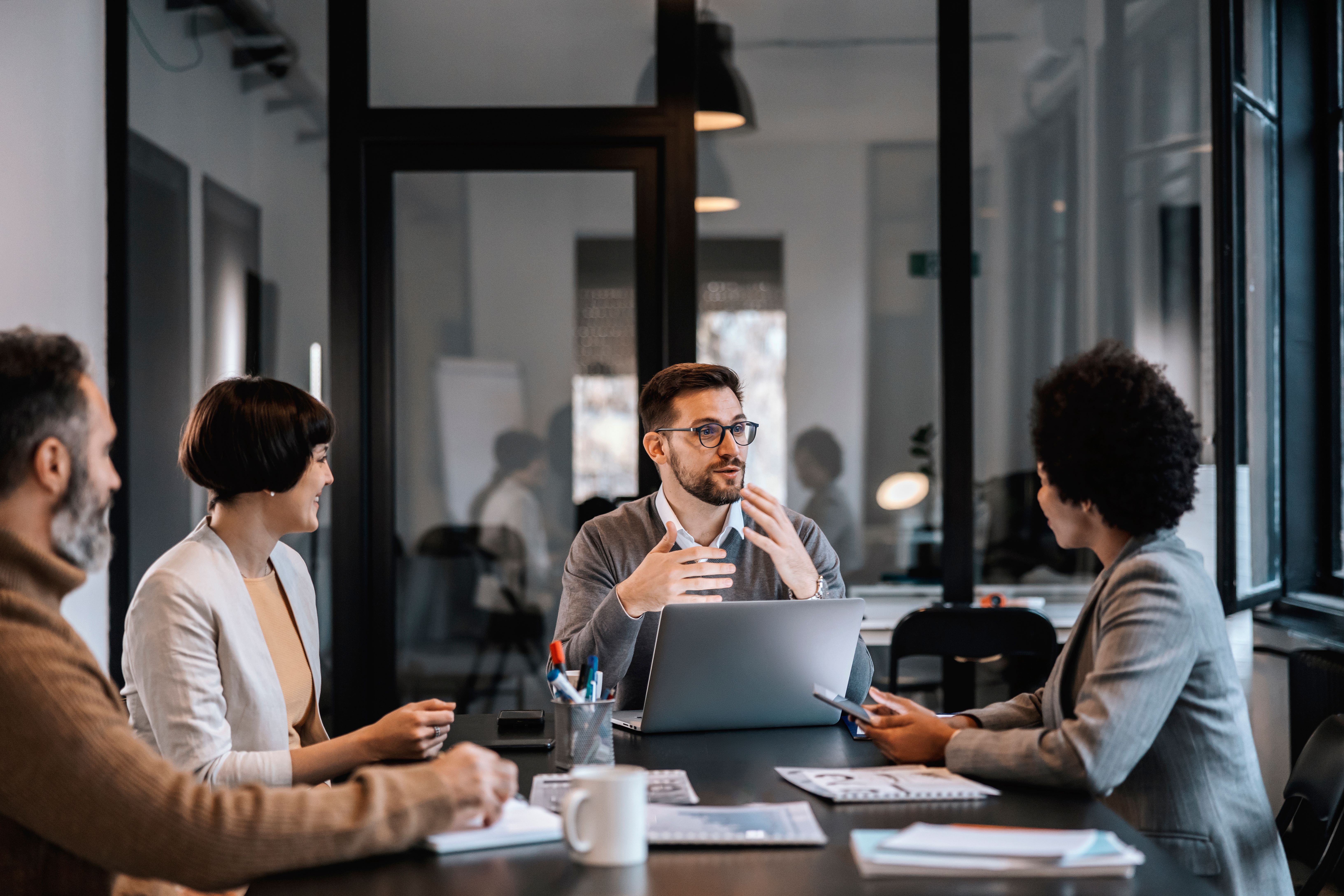 Group of people speaking and collaborating in a modern conference room