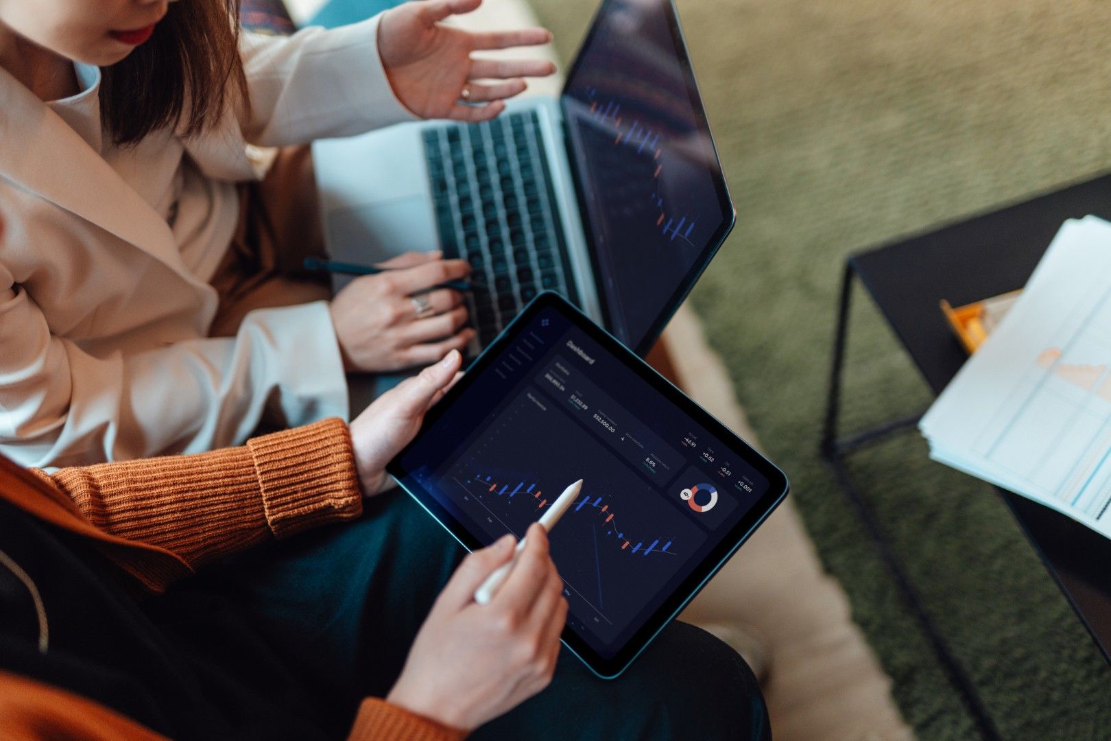 Two people holding a laptop and a tablet