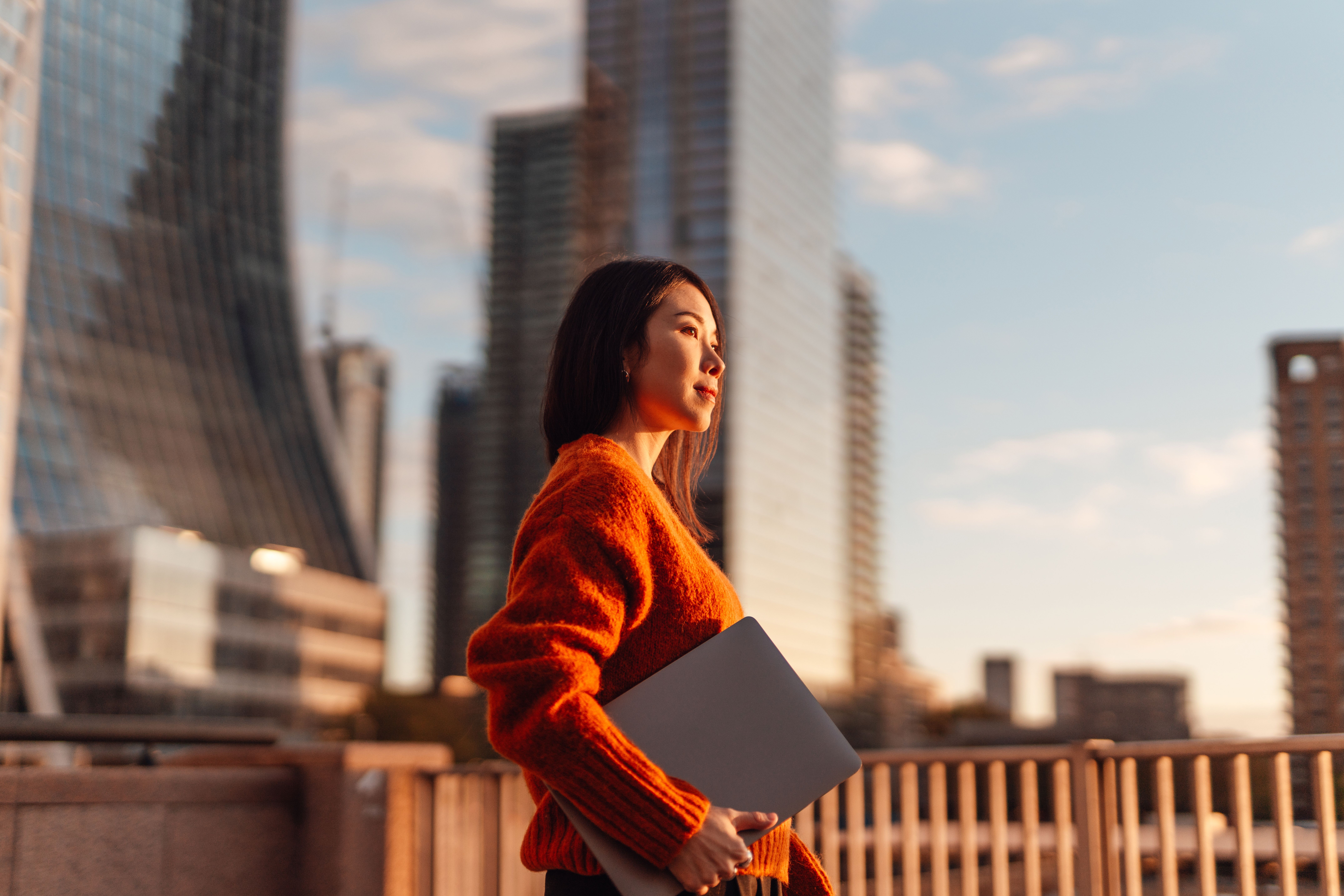Woman holding laptop outside
