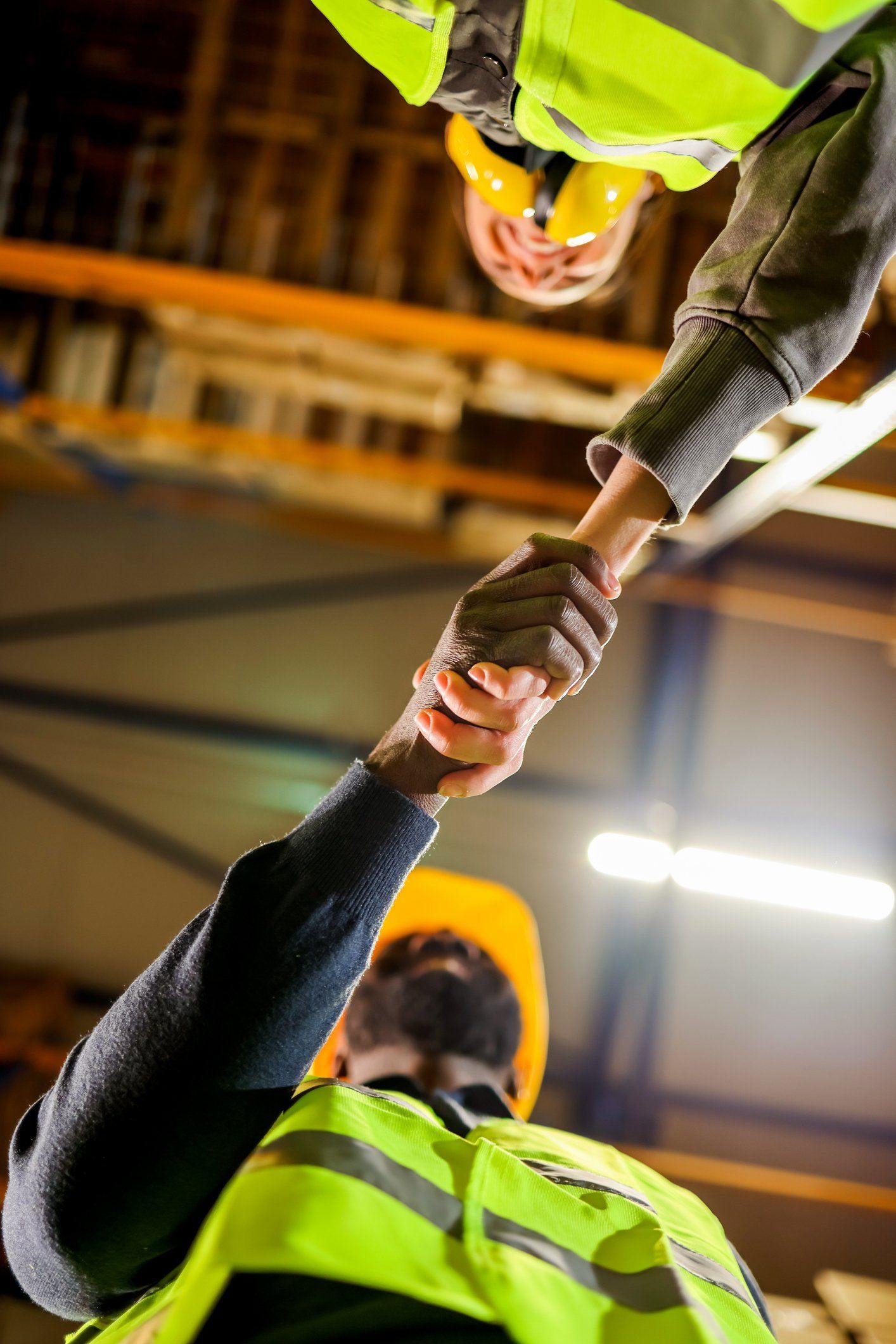 Two warehouse workers shaking hands