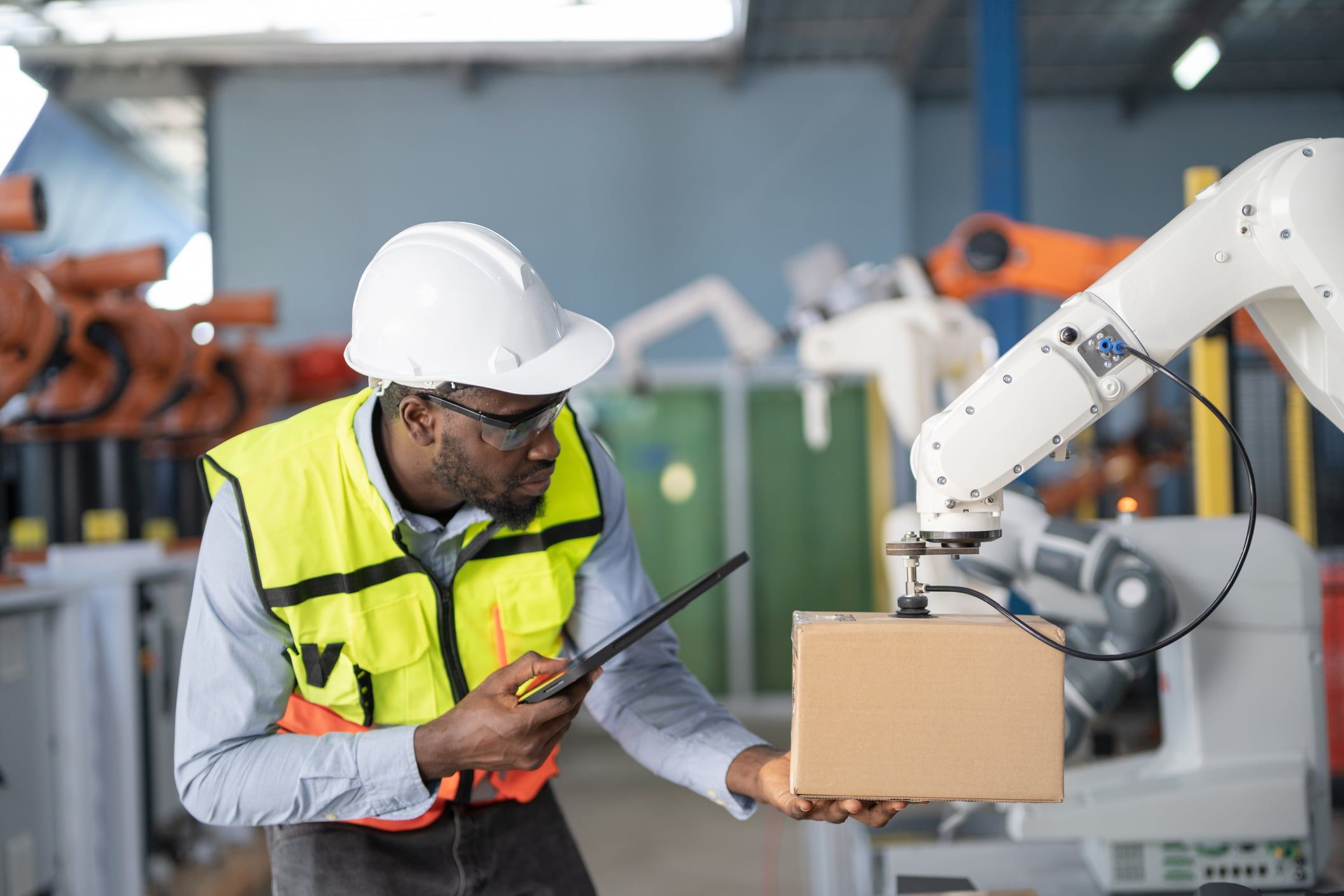 Warehouse worker grabbing a box from an automated arm