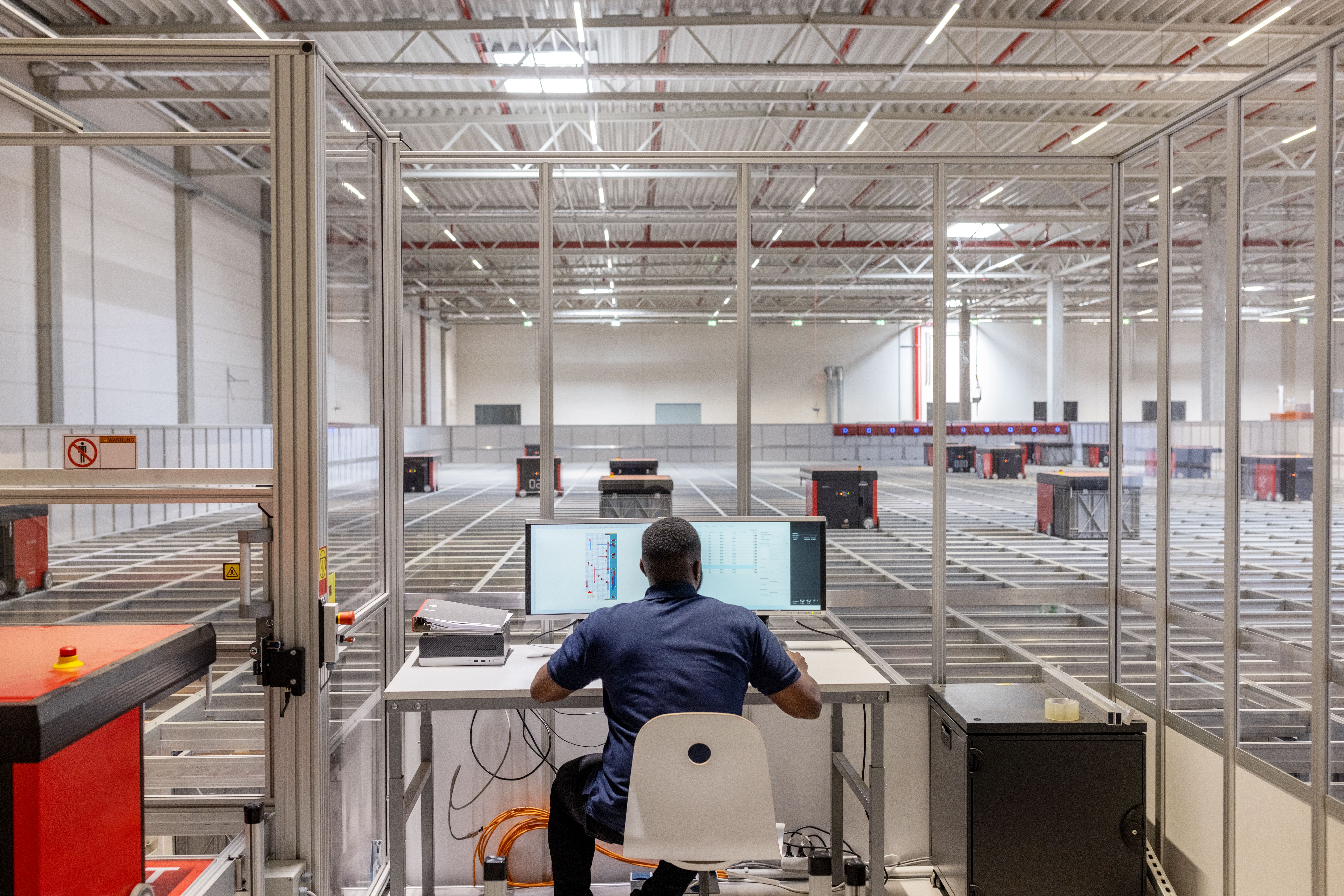 Worker overseeing autonomous mobile robot warehouse