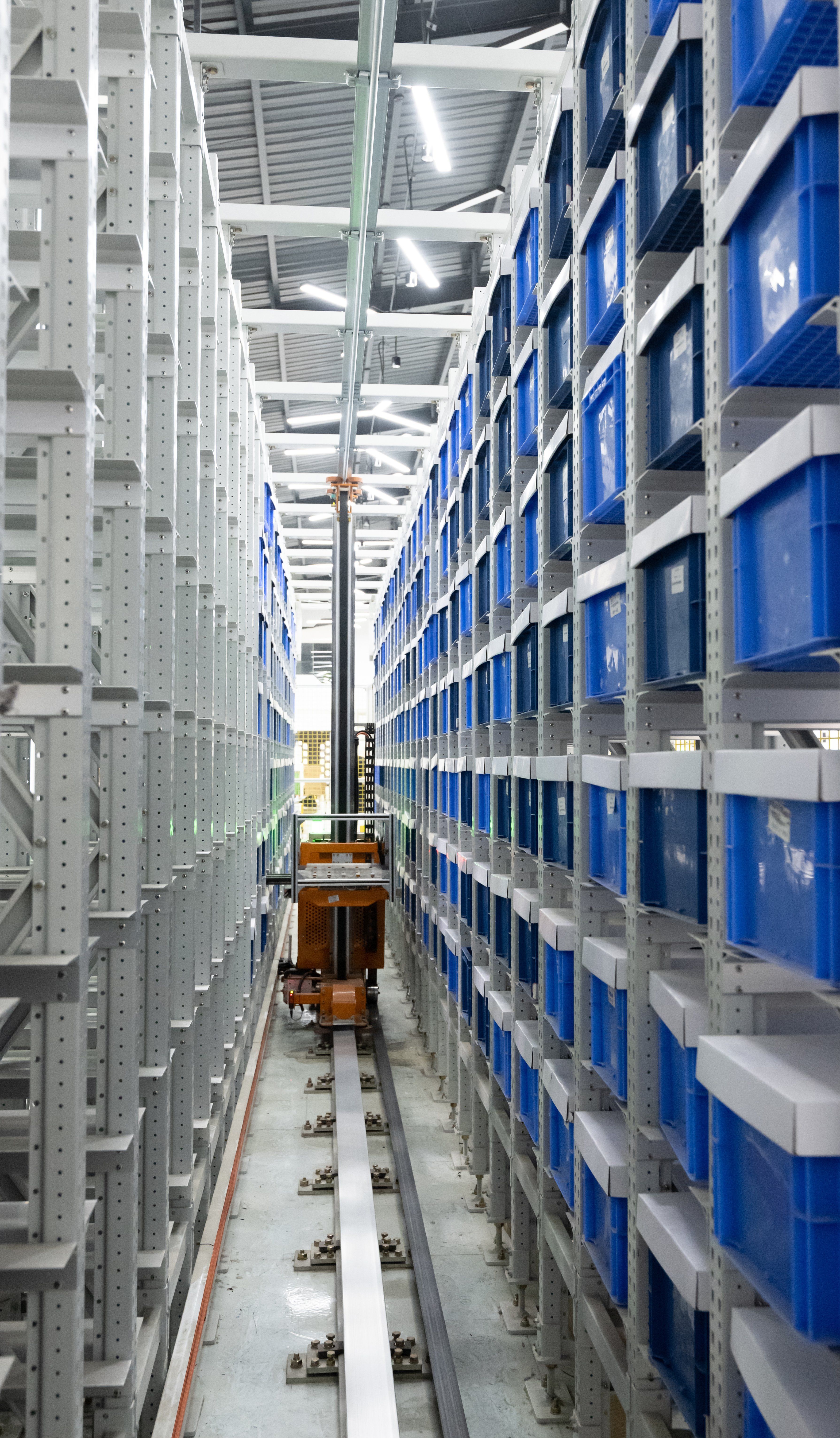 A close up of an AMR (Autonomous mobile robot) in a n aisle picking from baskets.