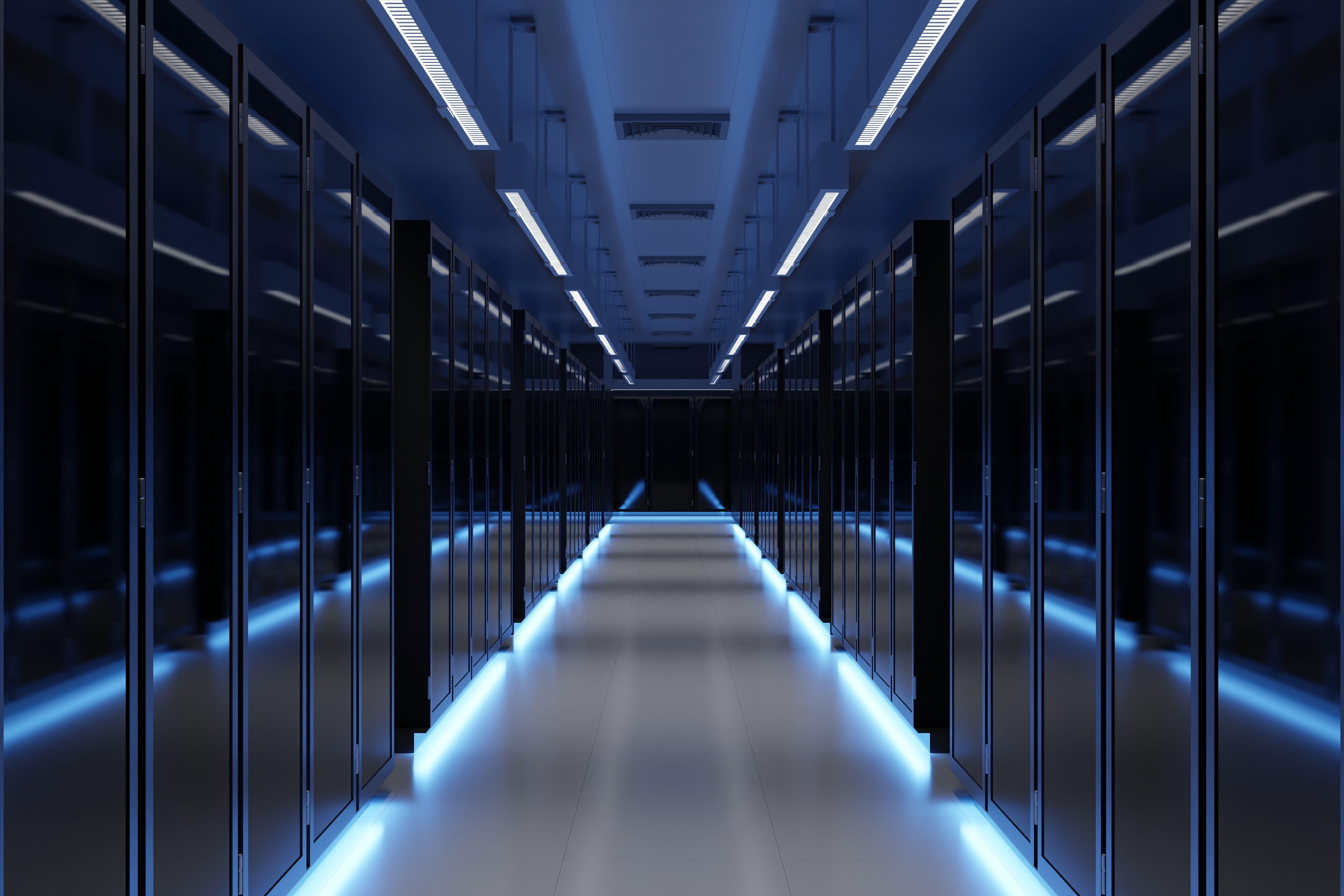 Long, empty data center aisle between rows of server racks lit by blue floor and ceiling lights