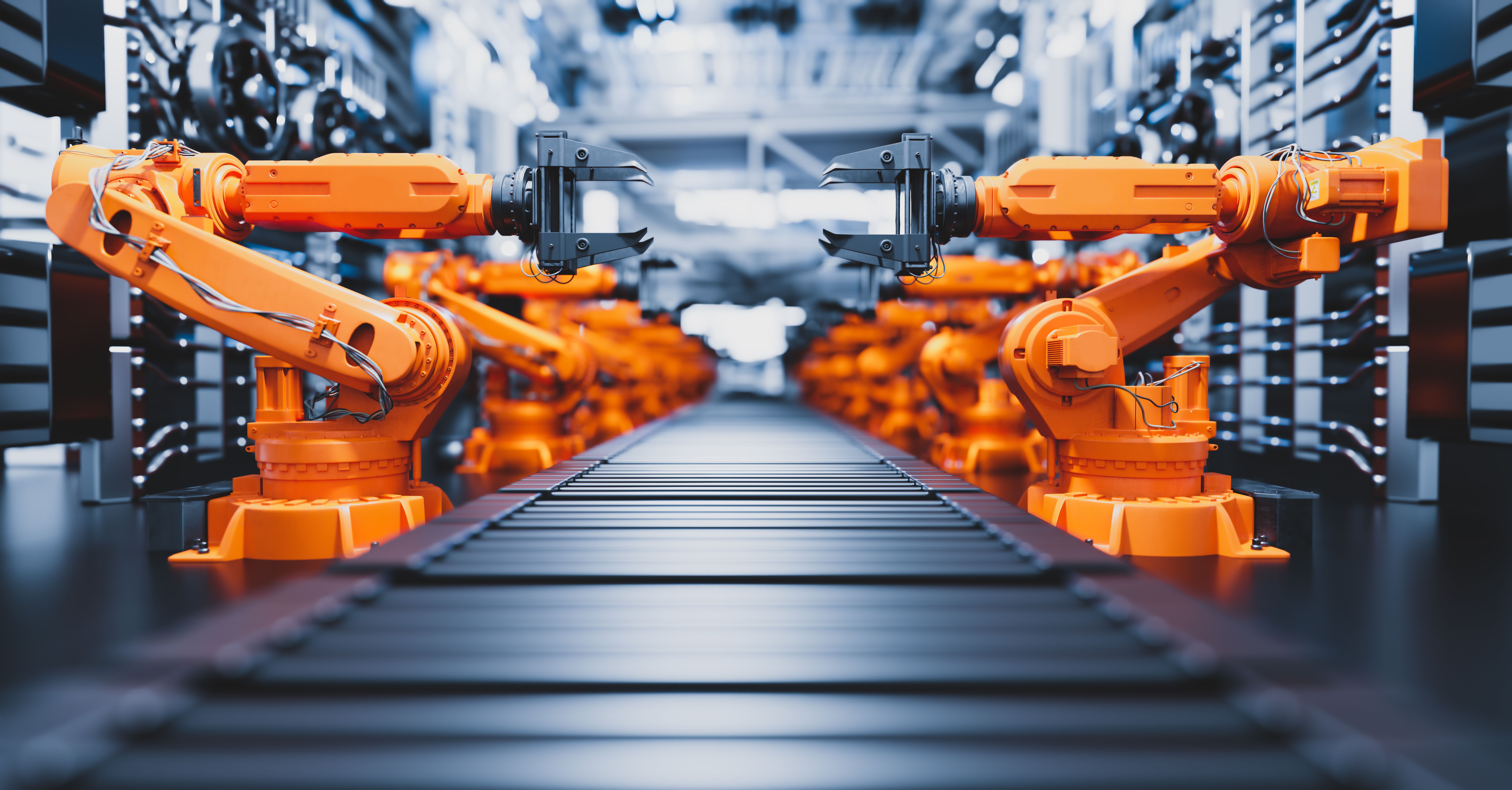 Rows of orange industrial robot arms lining a conveyor inside a factory