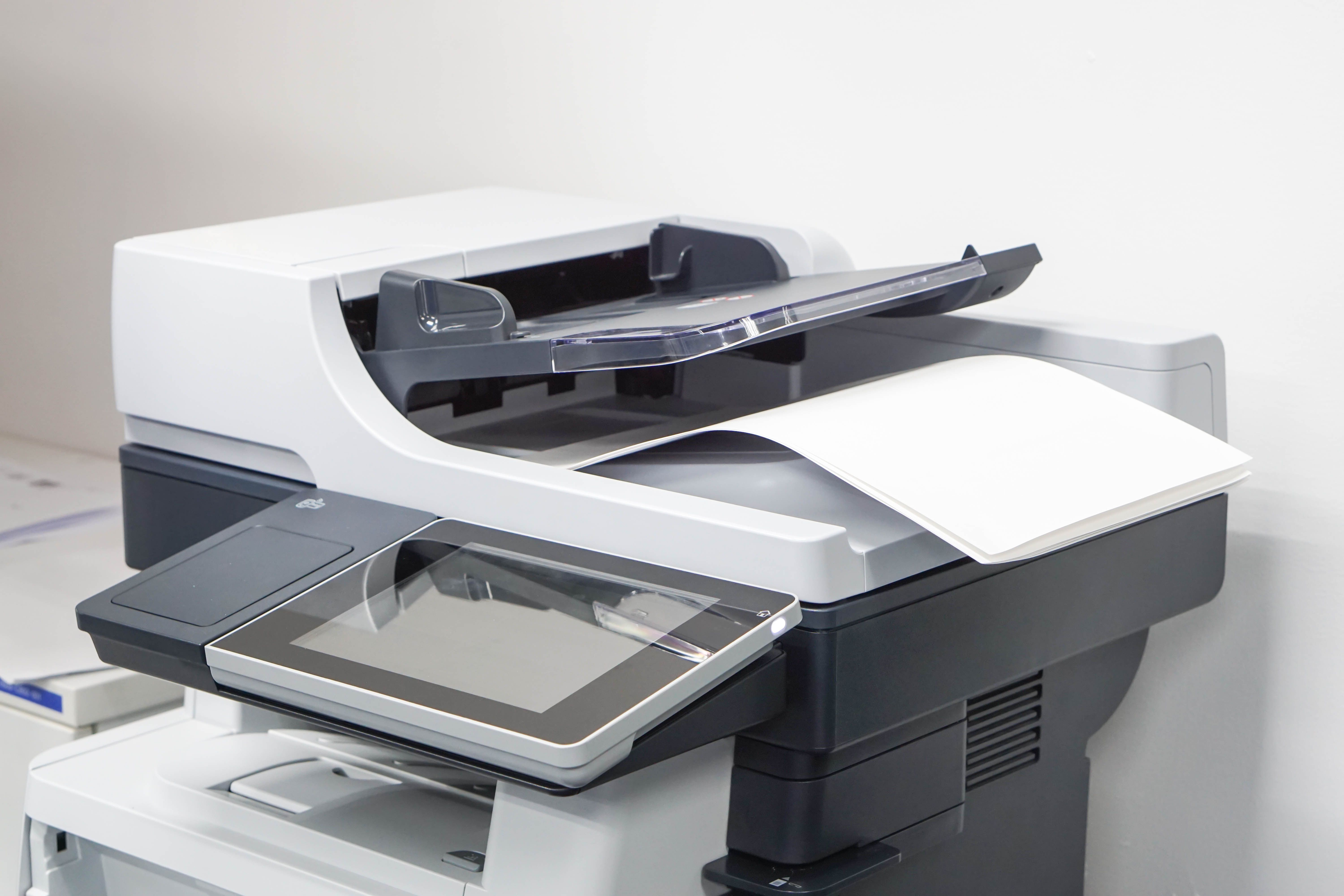 White enterprise multifunction laser printer with an automatic document feeder and paper output tray