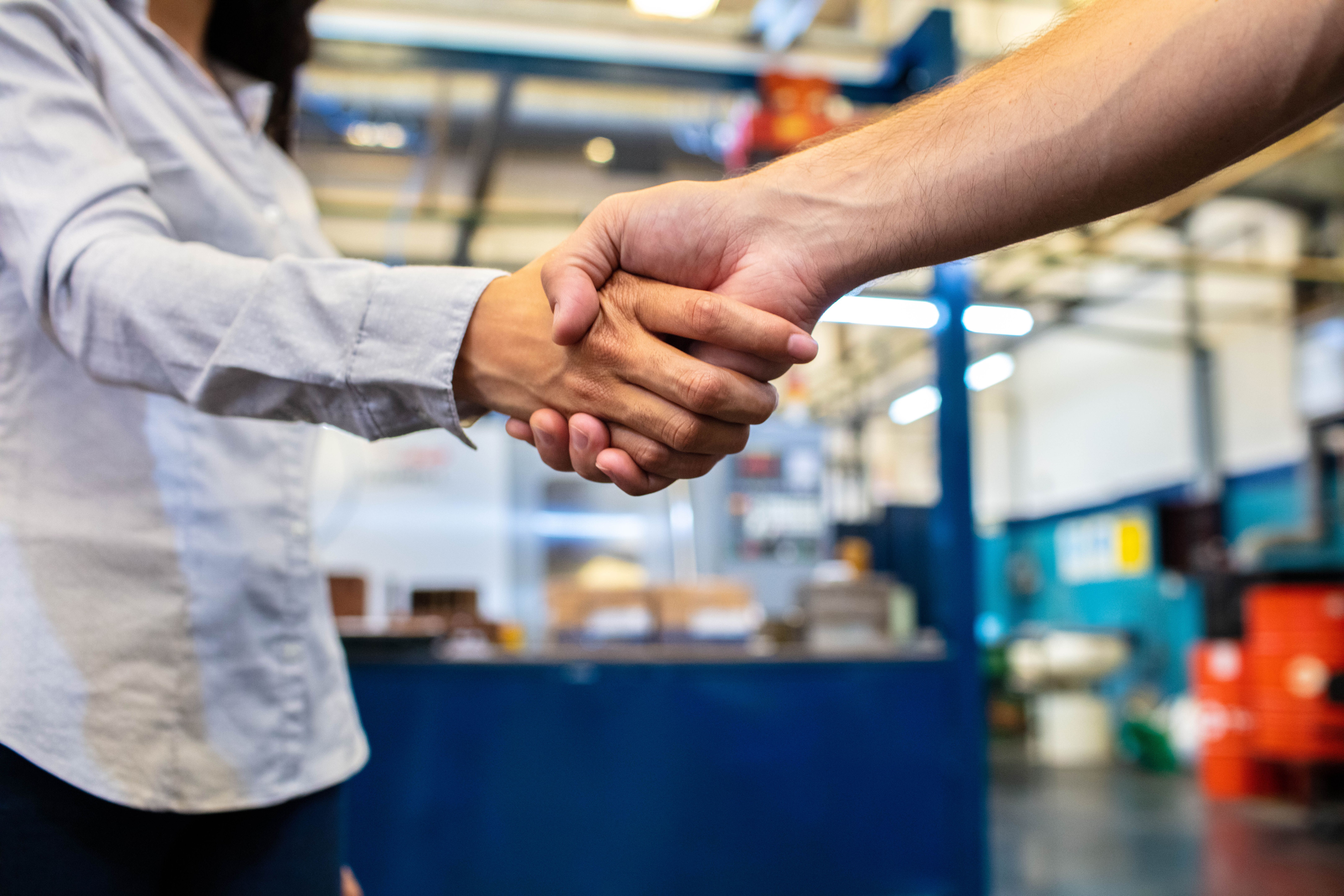 Two people handshaking in warehouse