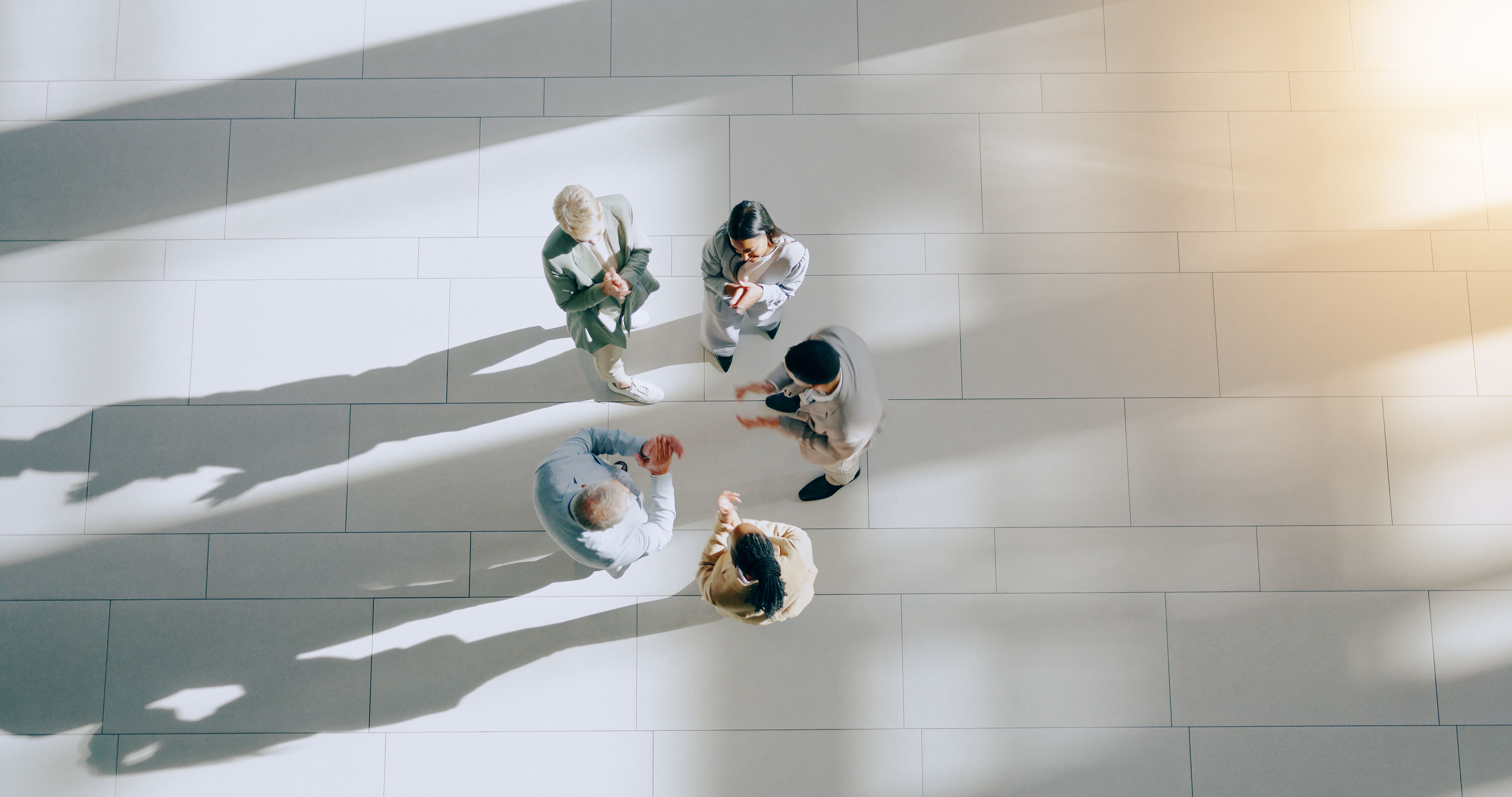 Group of people standing in a circle in a modern office environment 