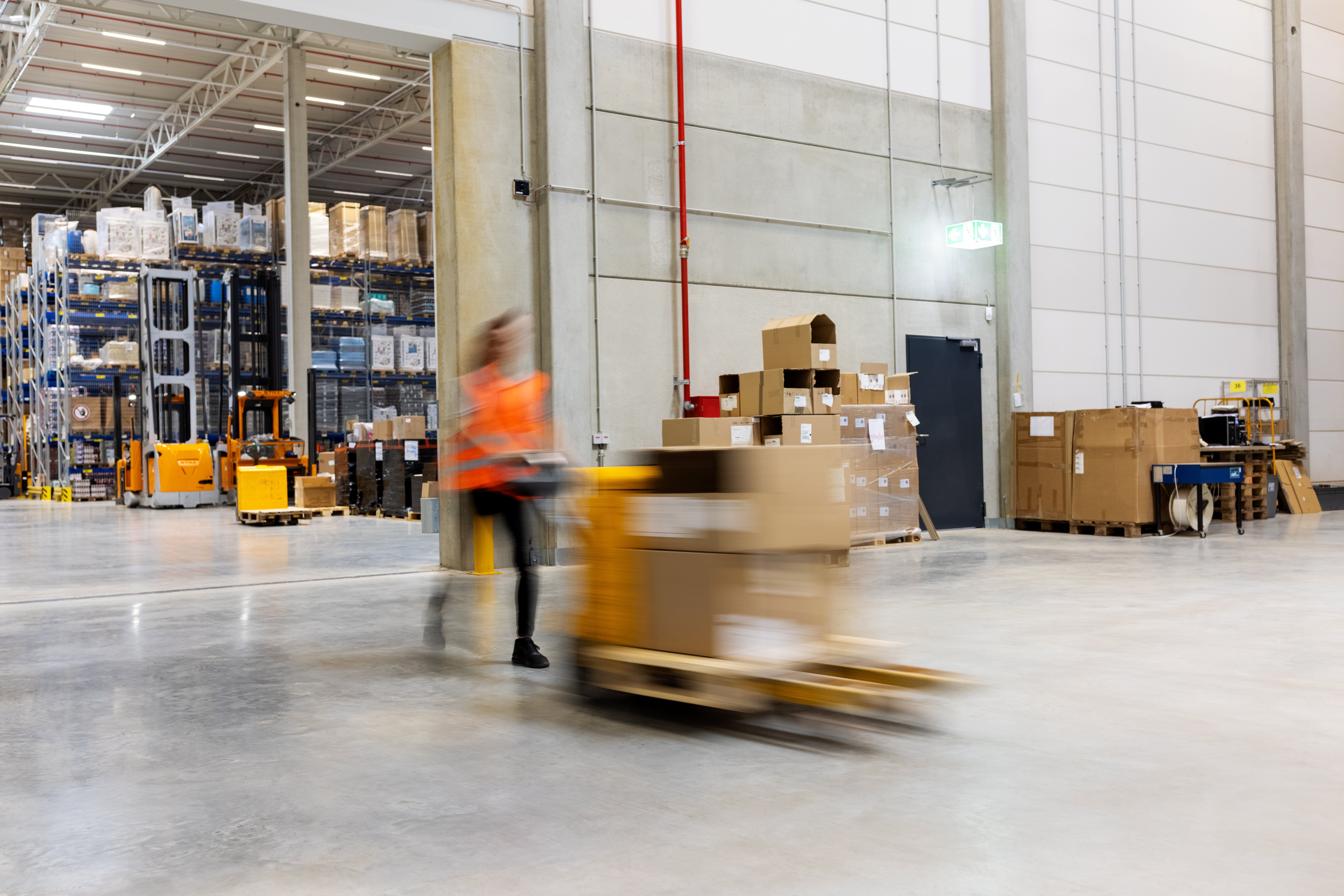 Warehouse worker moving a pallet in a logistics warehouse