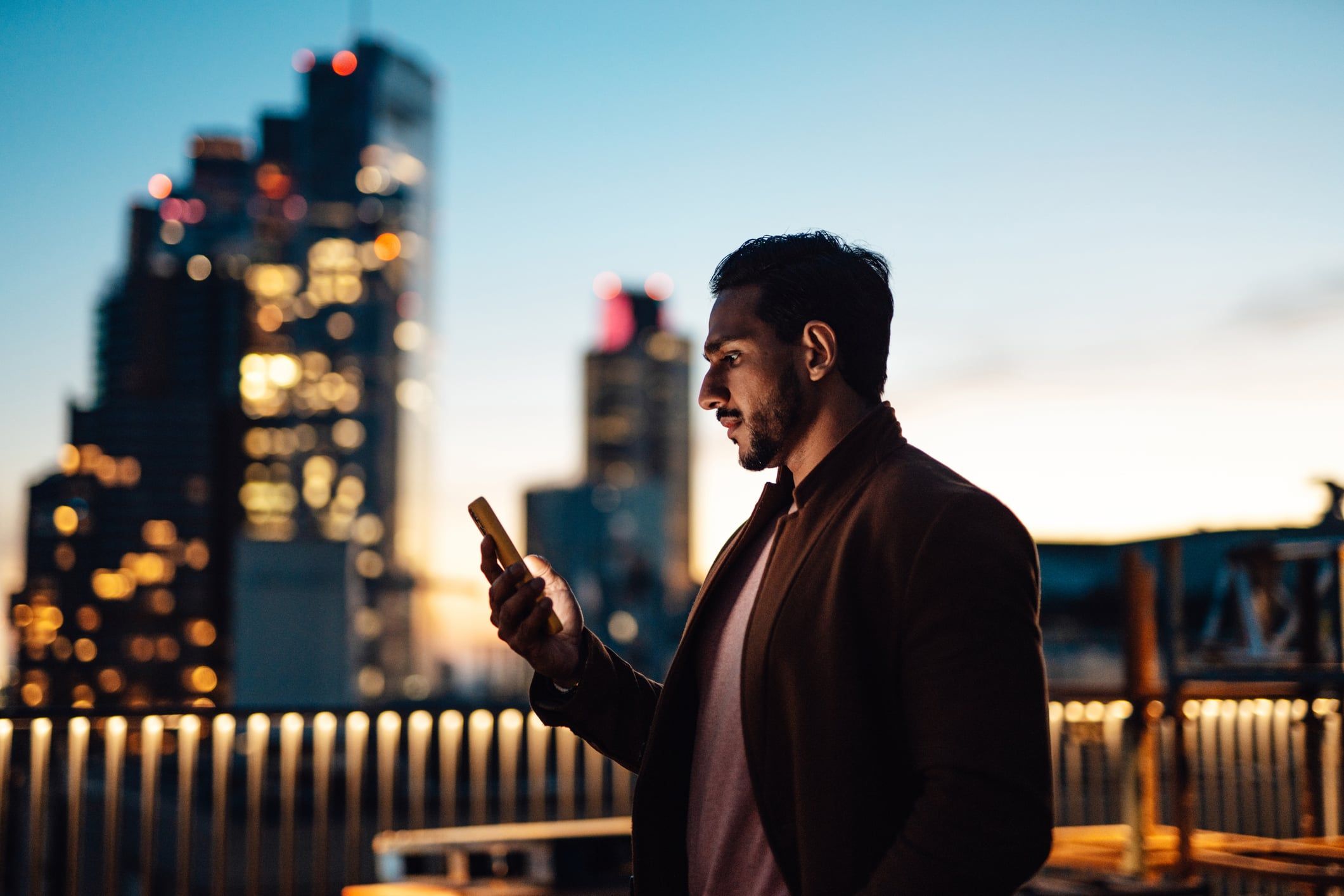 Man standing outside looking at a smart phone