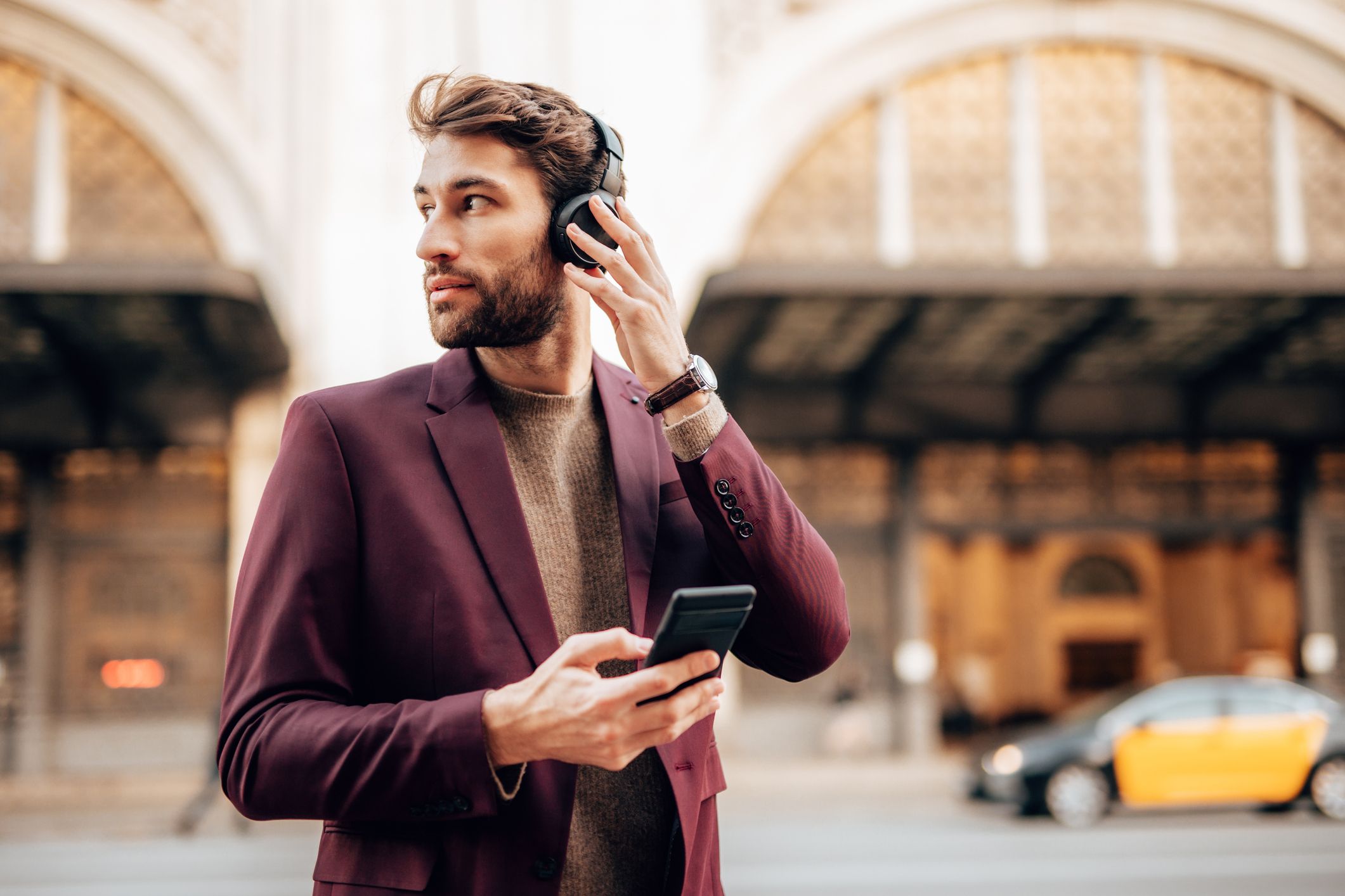 Man listening to headphones on a busy street