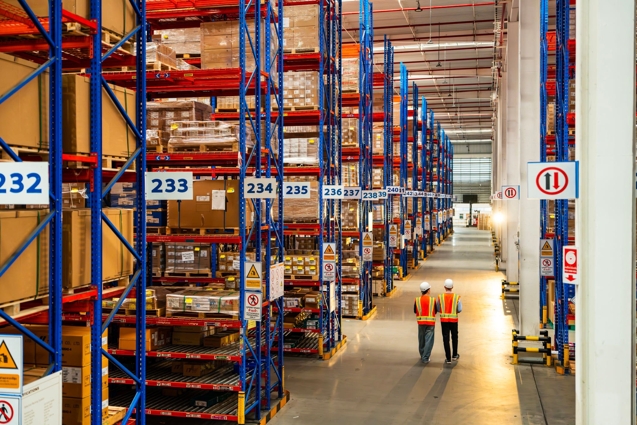 Two warehouse professionals walking in an empty warehouse