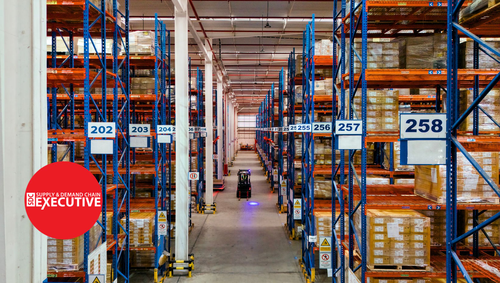 A warehouse with a single forklift moving between aisles