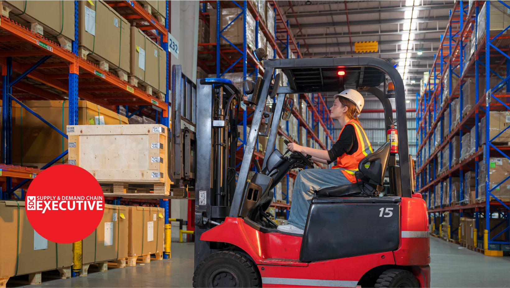 A woman operating a red forklift that is lifting a box onto a warehouse rack