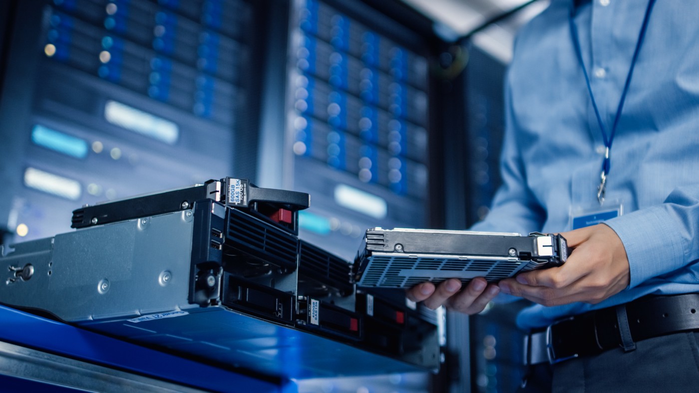 Technician sliding a rack server out of its rack in a data center